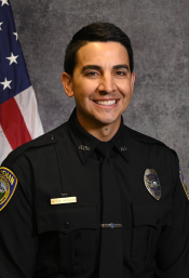 Headshot of Bozeman Police Officer Tartaglia posed in front of an American flag