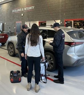 Two Bozeman Fire firefighters help a woman install a new car seat.
