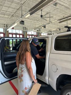 A Bozeman Fire firefighter helps a woman install a car seat in her truck.